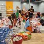 Smiling children participating in a hands-on art activity at the Kids' Art Party.