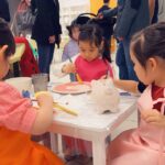 Kids collaboratively working on a mural, adding their artistic touch to a collective masterpiece