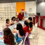 Children proudly presenting their finished art pieces at the Kids' Art Party.