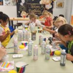 Inquisitive expressions on young faces as kids experiment with mixed media in an Art Party workshop.